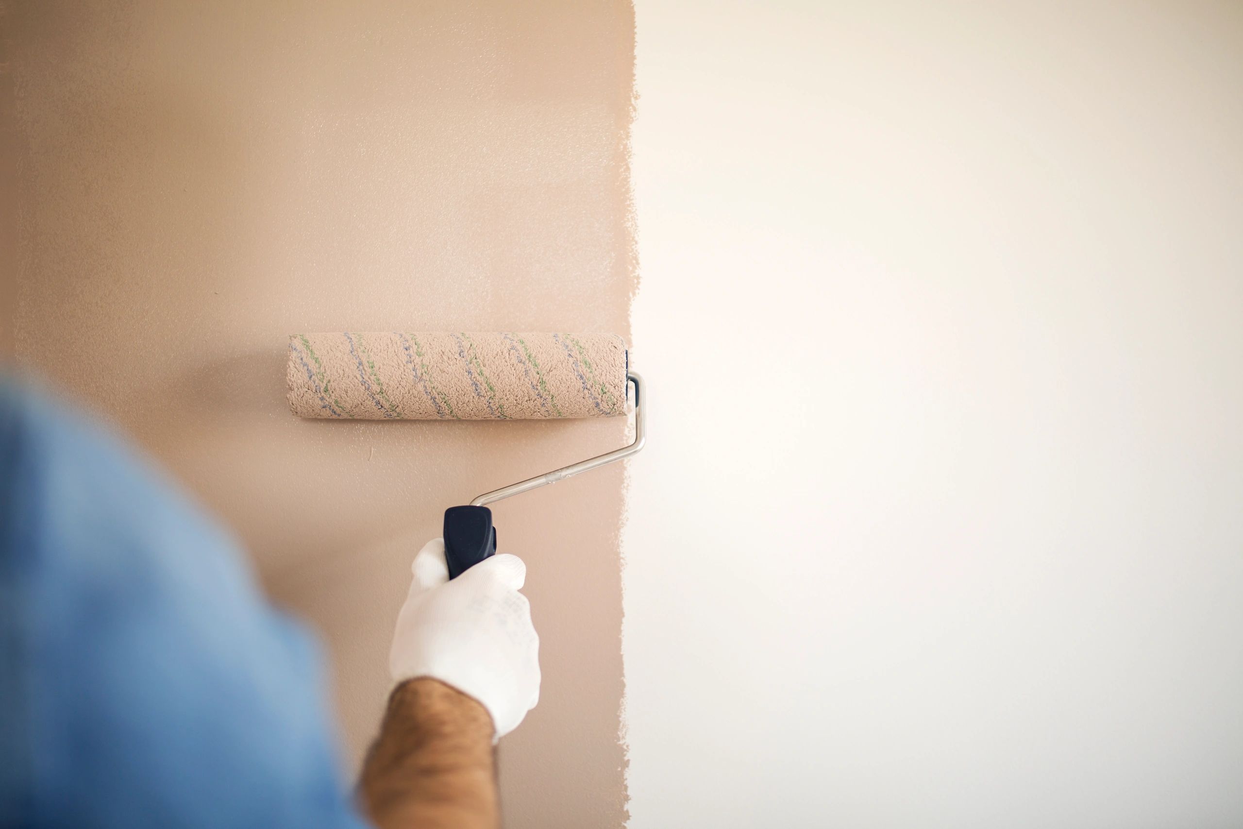 Close-up of paint roller applying paint to a wall