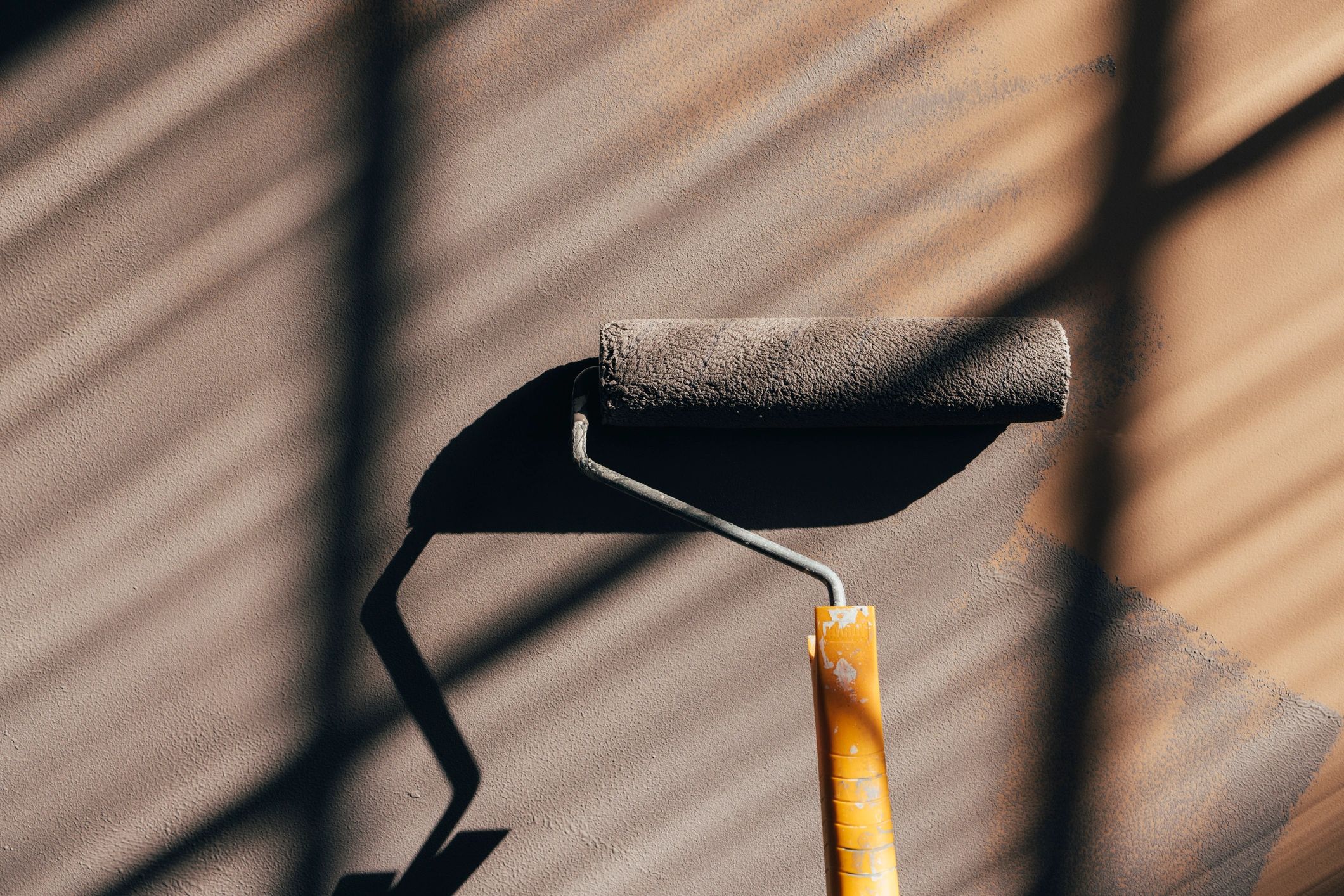Paint roller applying an even coat on a wall