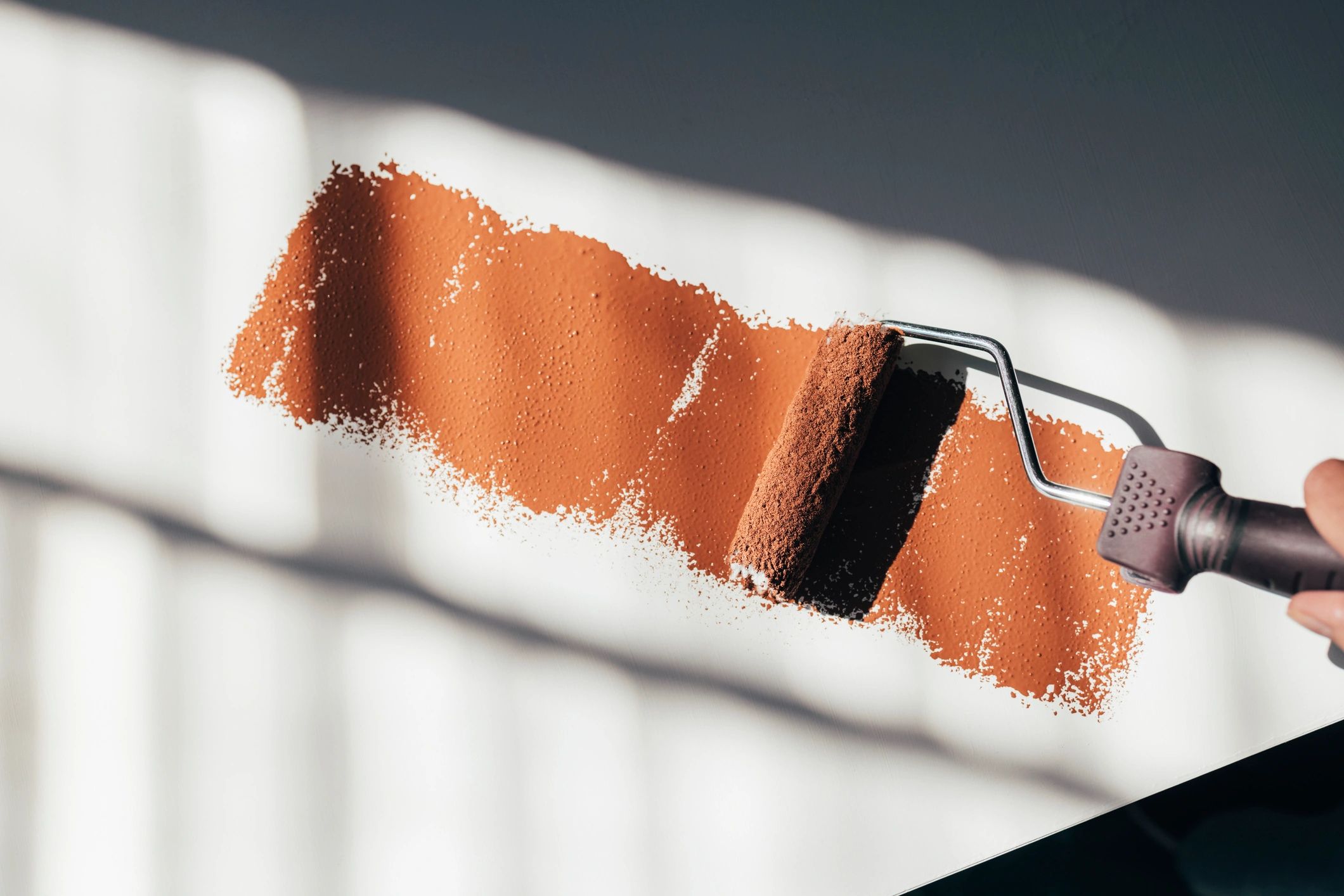 Paint roller applying a smooth coat to furniture