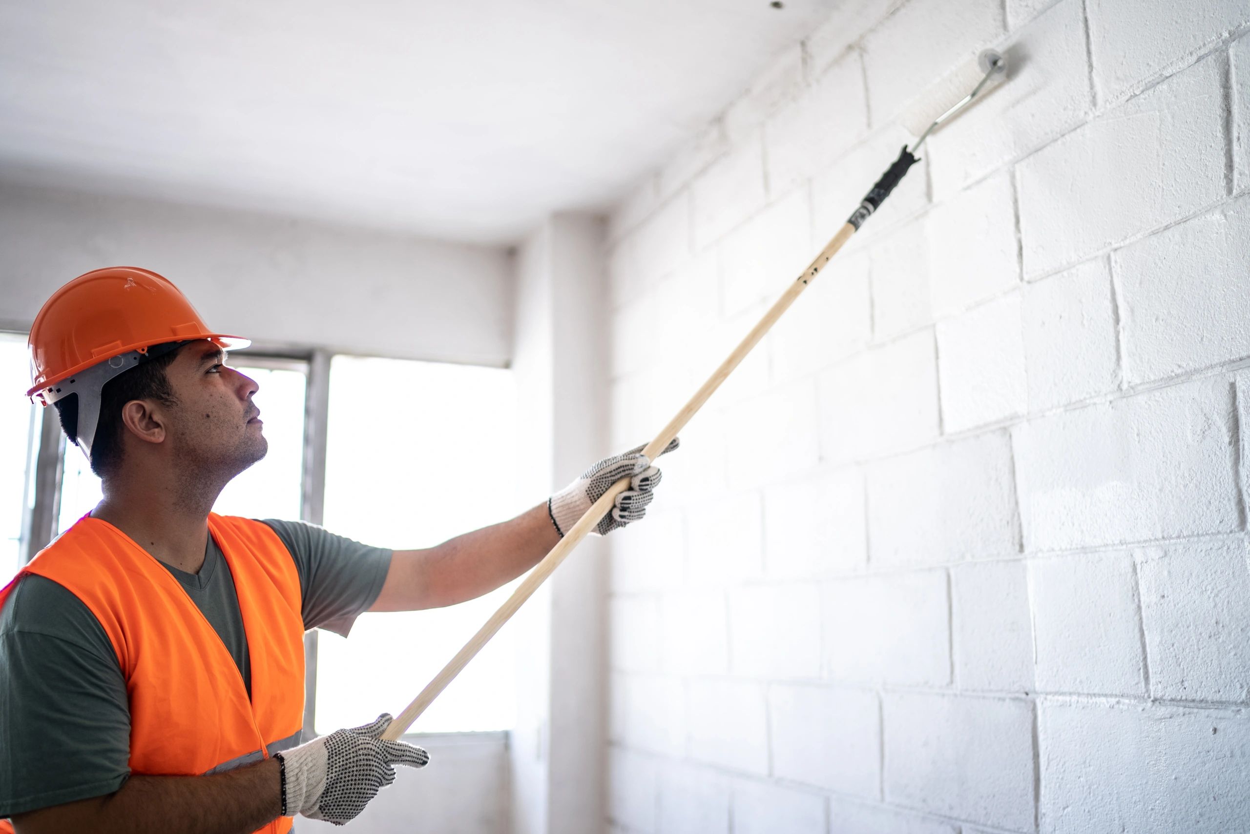 Professional painter applying paint to an interior wall