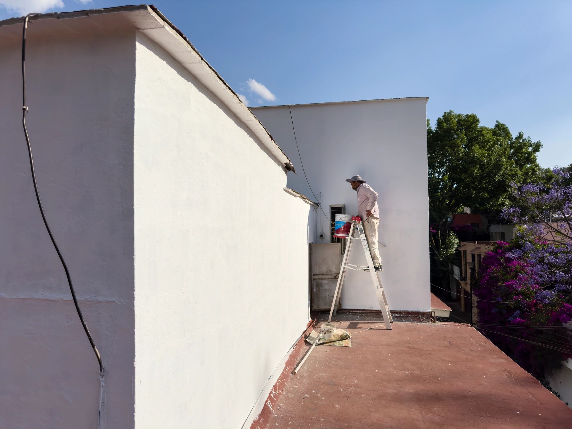 Worker painting an exterior surface