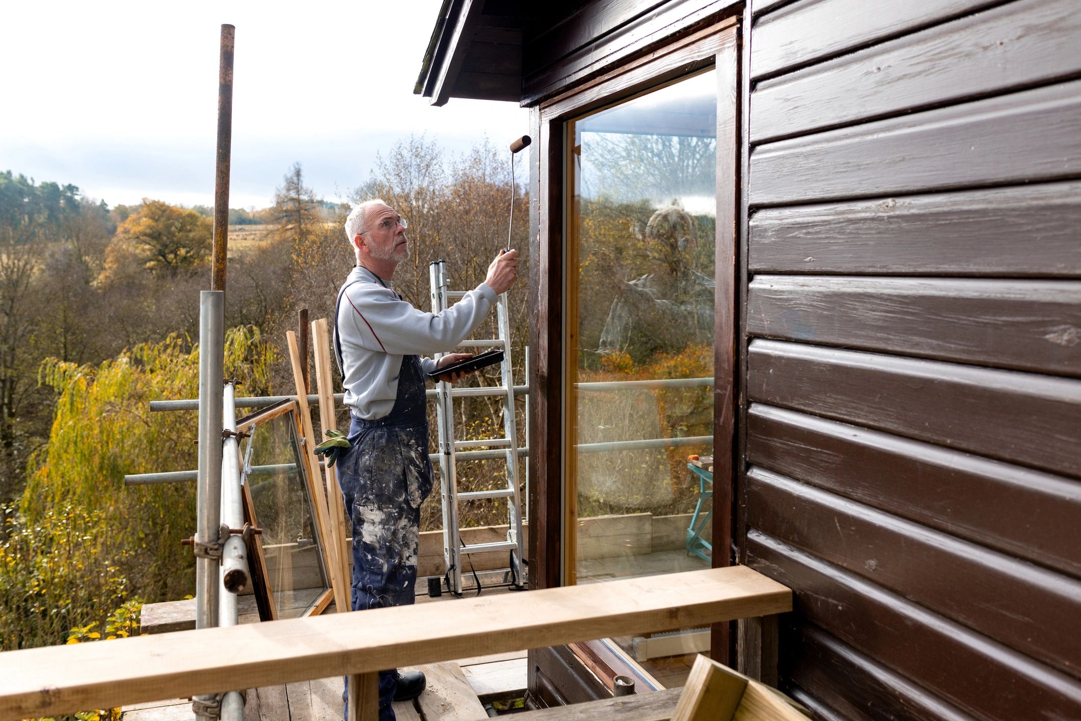 Decorator painting the exterior of a house from scaffolding