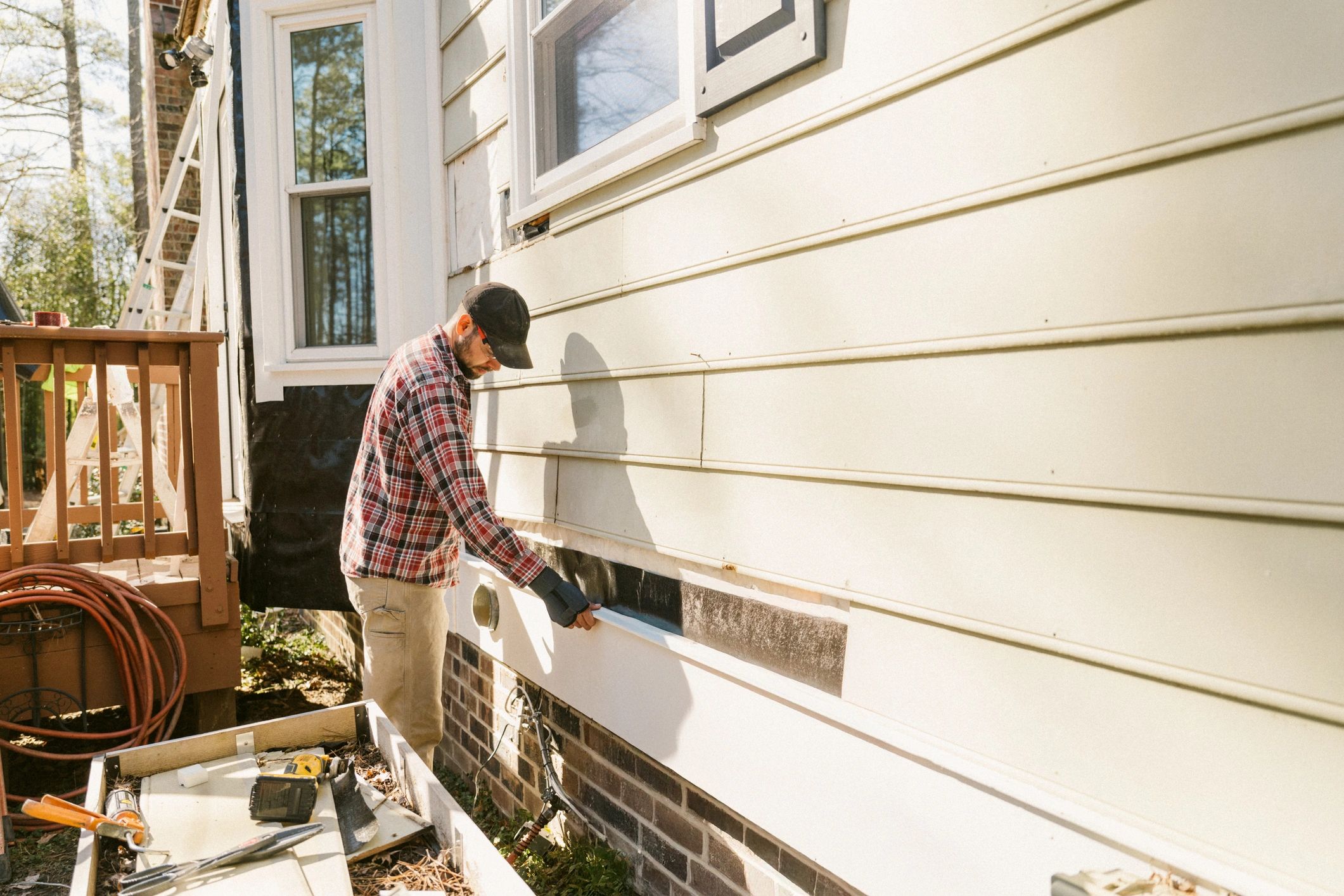 Contractor working on an exterior surface with ladder access